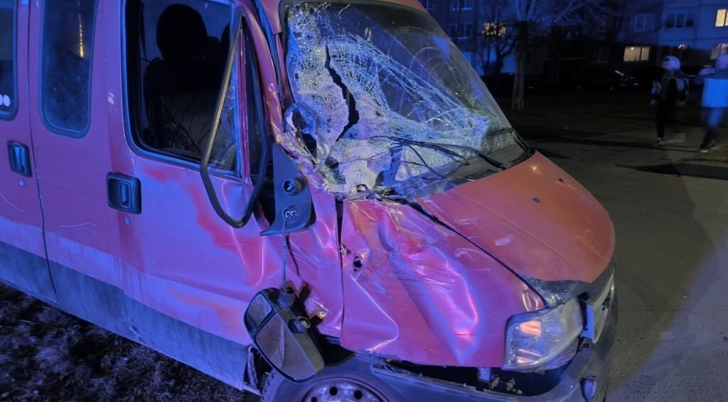 Close-up of crushed red commercial vehicle, illustrating machinery damage from a work site accident.