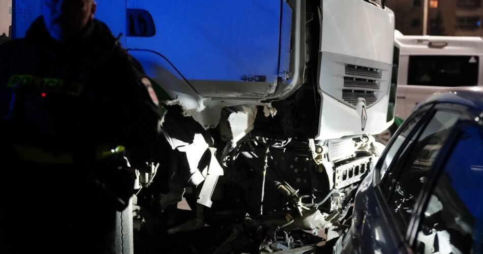 Commercial truck accident scene investigation with police officer.