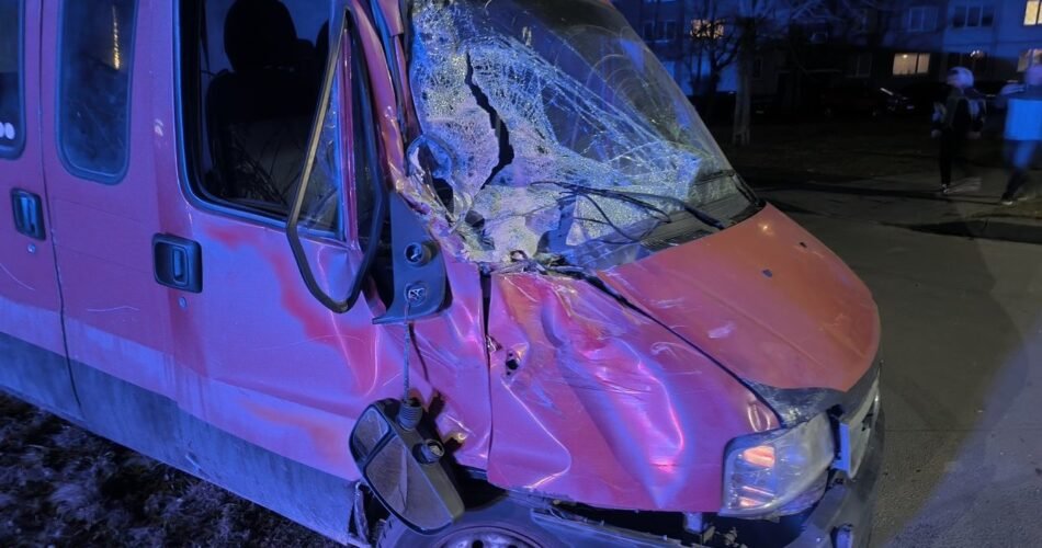 Close-up of crushed red commercial vehicle, illustrating machinery damage from a work site accident.