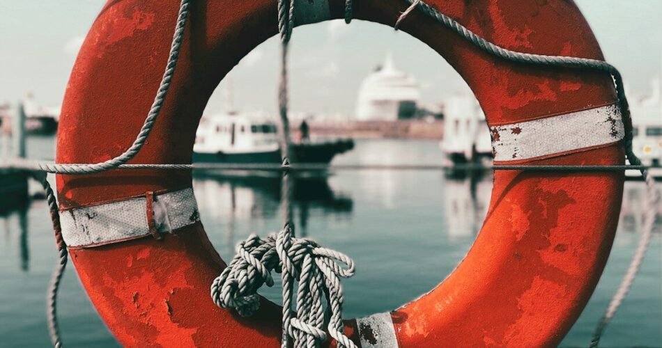 a life preserver on a dock with a boat in the background