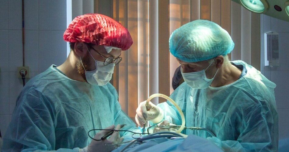 two men wearing blue lab coats